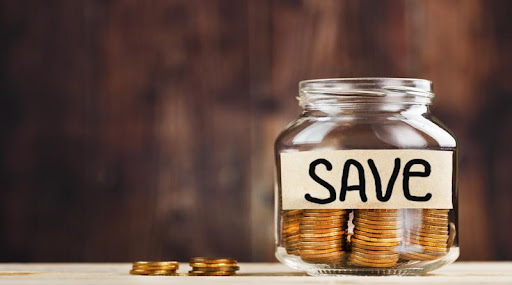 Image of a glass jar with pennies in it labelled as "Save".