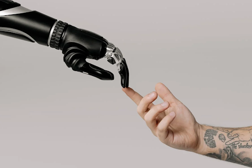 A robot hand touching the index finger of a human hand.