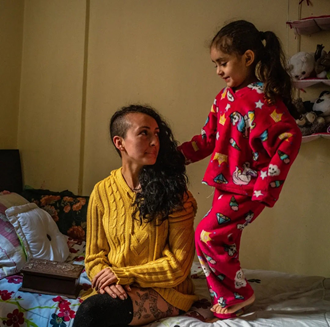 photo of a Latin American woman with her daughter in a night suit. 